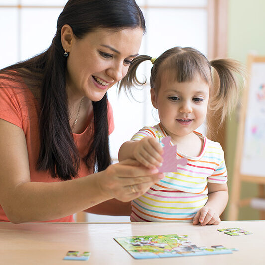 teacher-helping-toddler-with-puzzle